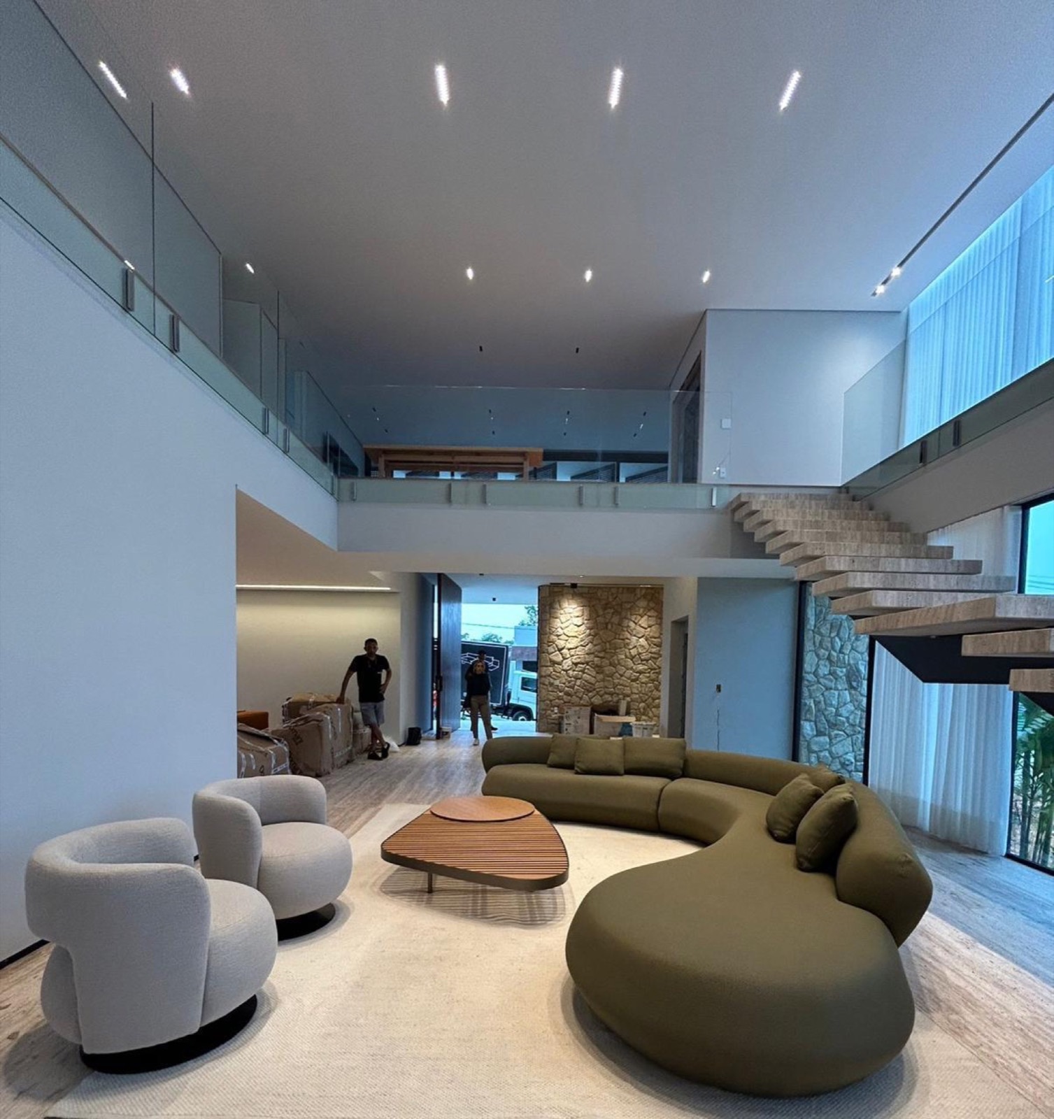 Sala de pé-direito duplo com piso inteiro em travertino levigado
